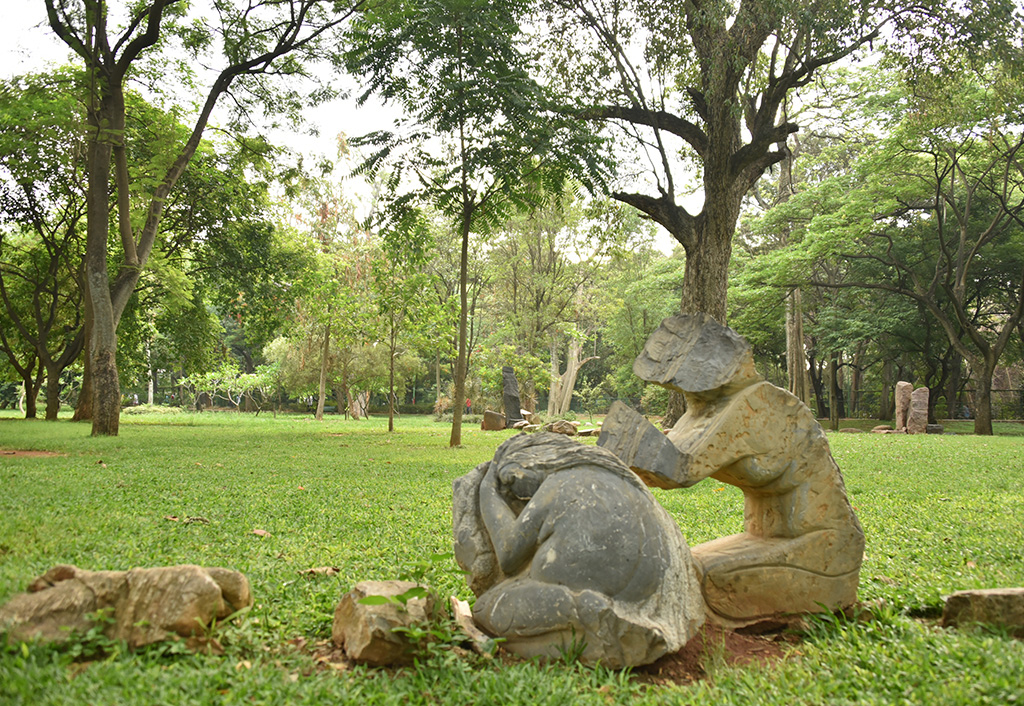Stone sculptures in a lush garden near The Oberoi Bengaluru