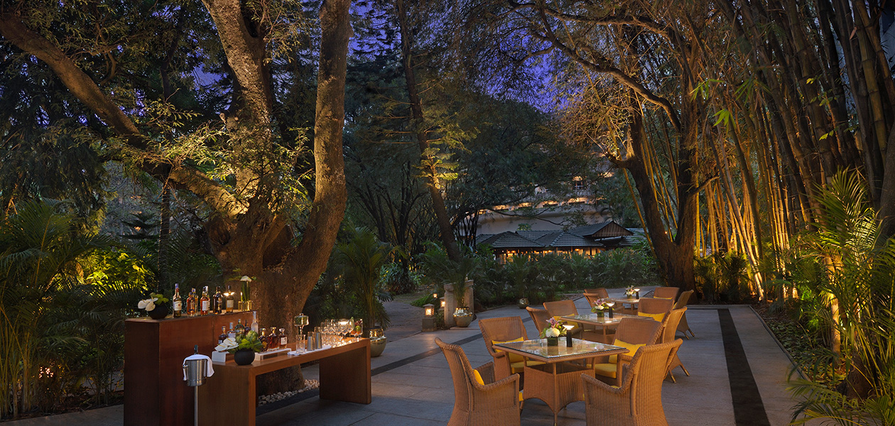 Outdoor dining area at The Oberoi Bengaluru's garden setting.