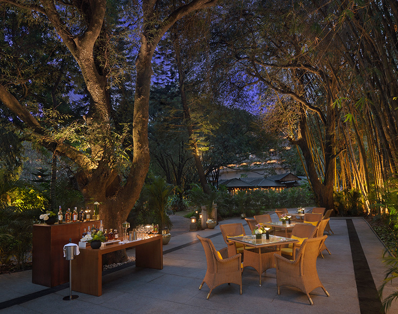 Outdoor dining area at The Oberoi Bengaluru, evening ambiance.