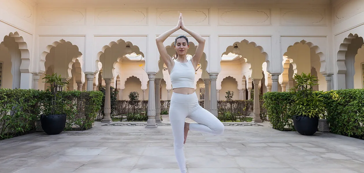Woman practicing yoga at The Oberoi Sukhvilas, Siswan Forest Resort