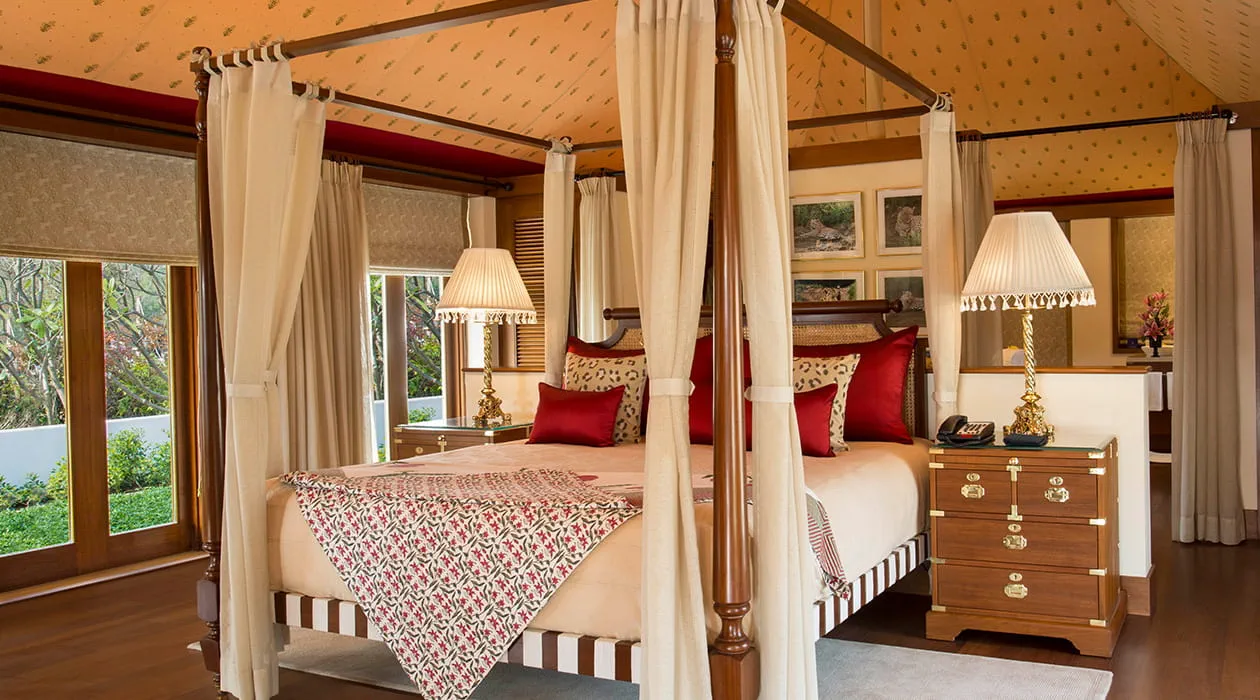 Four-poster bed with red pillows in luxury resort room