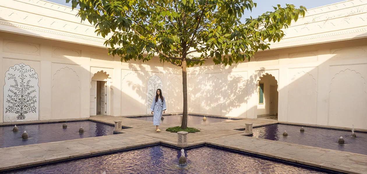 Woman walking near fountain courtyard, The Oberoi Sukhvilas, Siswan Forest Resort