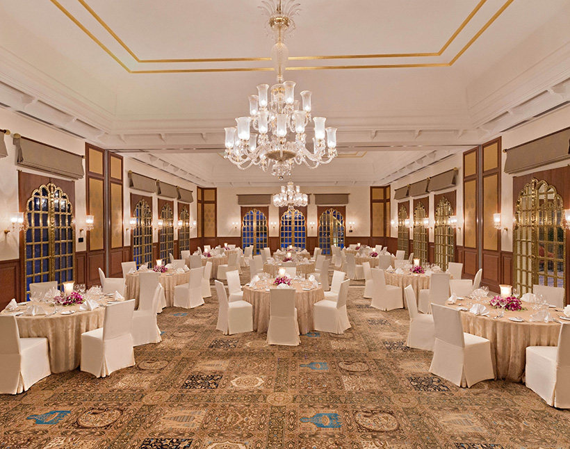 A luxurious dining hall at The Oberoi Sukhvilas with chandeliers