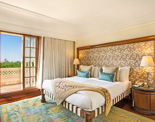 Spacious bedroom with traditional design elements in the Deluxe Suite with Balcony at The Oberoi Amarvilas, Agra.