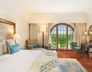 Comfortable seating space in the Deluxe Suite at The Oberoi Amarvilas, Agra overlooking verdant surroundings.