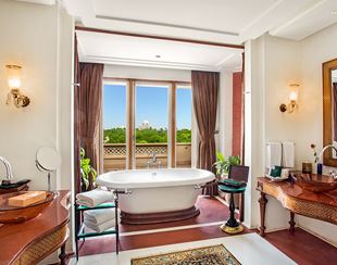 Spacious marble-clad bathroom in the Kohinoor Suite at The Oberoi Amarvilas, Agra with a freestanding bathtub.