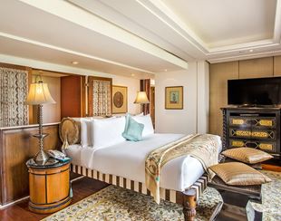 Luxurious bedroom in the Kohinoor Suite at The Oberoi Amarvilas, Agra with intricately carved headboards and soft lighting.