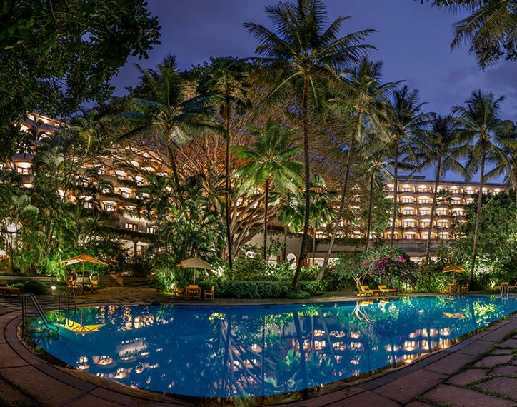 The Oberoi Bengaluru hotel pool illuminated at night.