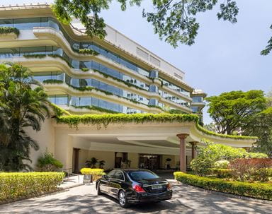 5 Star Hotel The Oberoi Bengaluru with parked car outside.