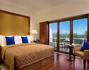 Luxurious room at The Oberoi Bengaluru with balcony view.