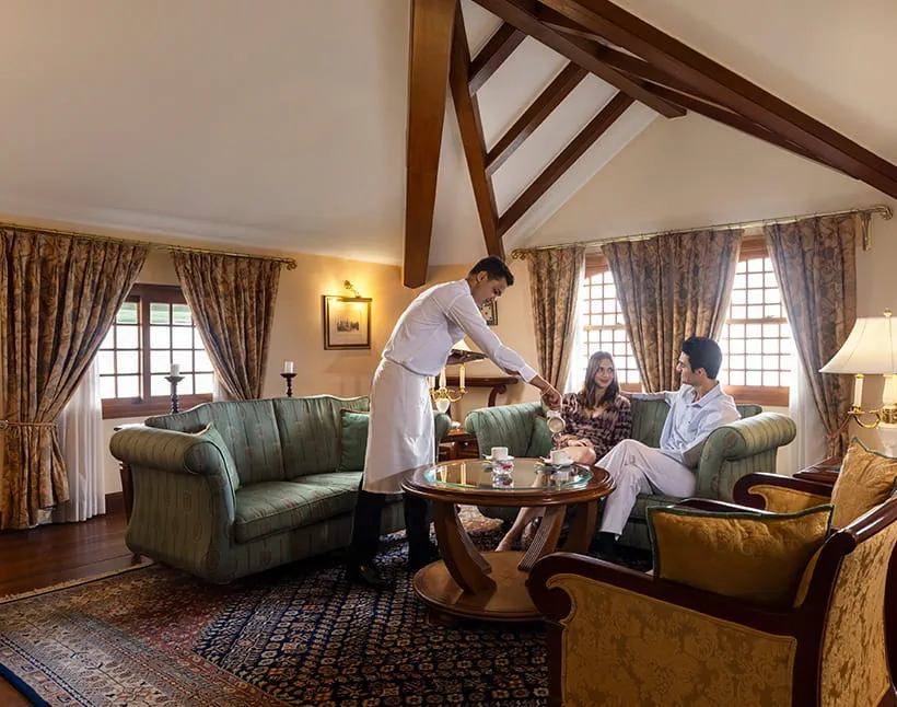 Waiter serving tea to couple in luxury hotel room, Shimla