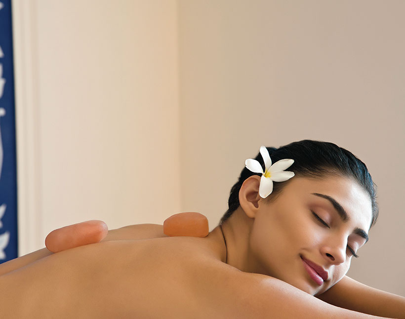 Woman relaxing with hot stones at luxury hotel spa in Shimla