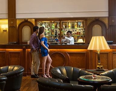 Couple at bar inside The Oberoi Cecil, a luxury hotel