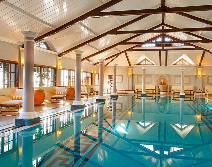 Indoor pool with lounge chairs at luxury hotel in Shimla