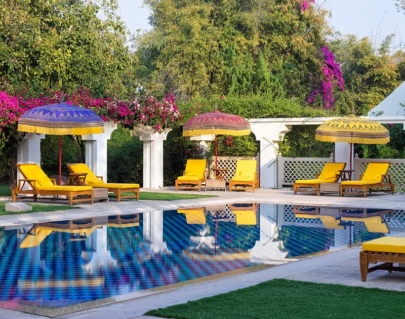 Poolside loungers with umbrellas, luxury hotel in Shimla, vibrant garden setting