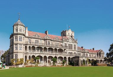Grand historical building with lush lawn in Shimla Luxury hotel nearby