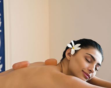Woman relaxing with hot stones at luxury hotel spa in Shimla