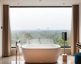 Luxurious bathtub facing scenic view at The Oberoi New Delhi