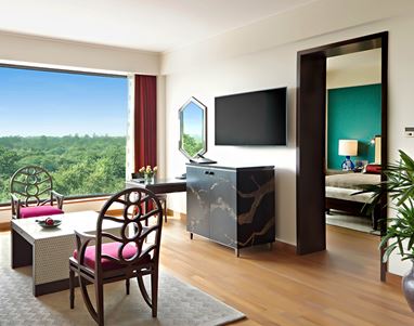 Luxury hotel room with chairs, table, and scenic view at The Oberoi