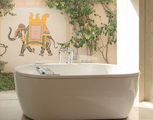 Luxurious bathtub, sunlit, elephant mural, foliage at The Oberoi Sukhvilas