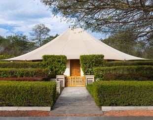 Luxurious tent at The Oberoi Sukhvilas, surrounded by greenery and gardens