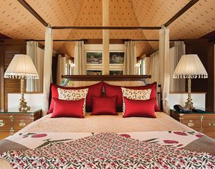 Luxurious bed with red pillows in The Oberoi Sukhvilas Resort