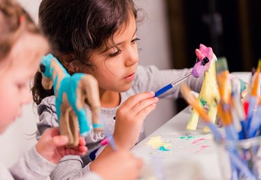 Children painting toy animals at a craft table in The Oberoi Sukhvilas