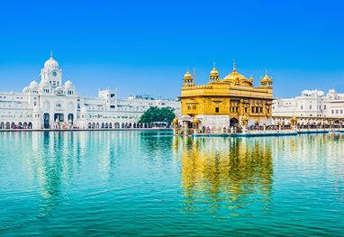 Golden Temple reflecting in water under clear sky
