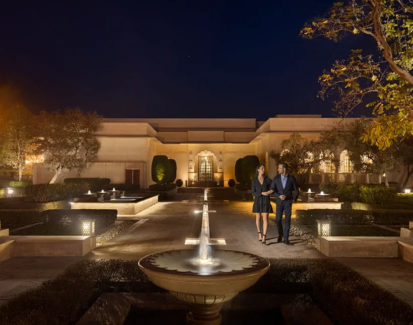 Couple walking at night in The Oberoi Sukhvilas, a 5-star resort