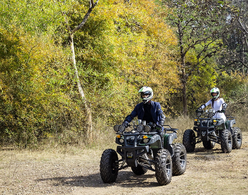 ATVs being ridden in a forest near The Oberoi Sukhvilas resort