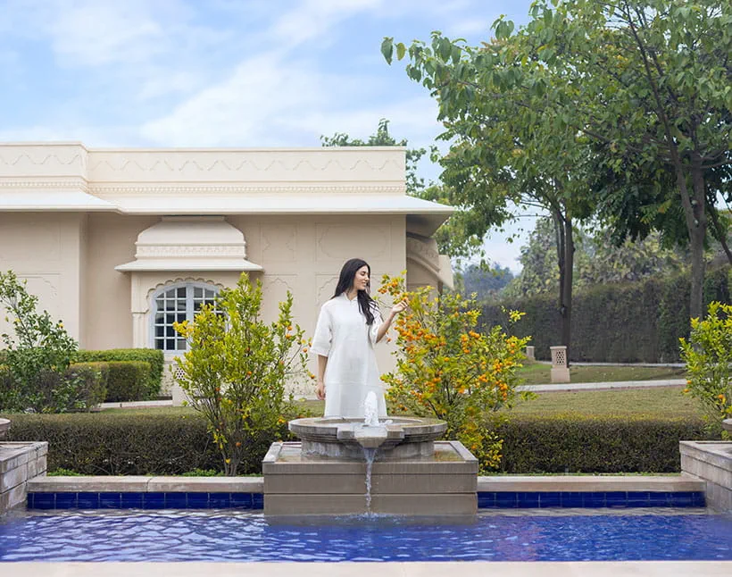 Woman in white dress by fountain at The Oberoi Sukhvilas