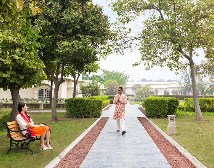 Man walking in garden of The Oberoi Sukhvilas, luxury resort