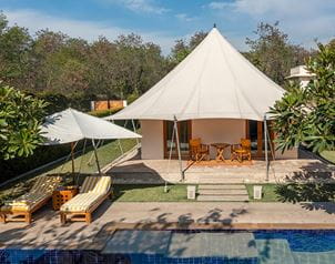 Luxury tent at The Oberoi Sukhvilas, Siswan Forest Resort with poolside loungers