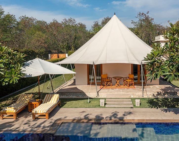 Luxury tent at The Oberoi Sukhvilas, Siswan Forest Resort with poolside loungers