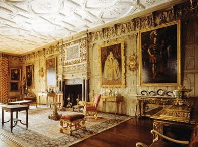 View of the ballroom, at Knole, Sevenoaks, Kent in England, featuring a decorative chimney piece, gilded furniture and plasterwork ceiling 