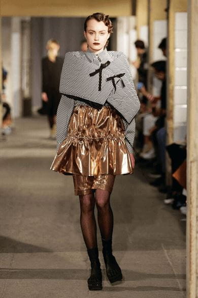 A model dons Arbesser’s quilted, black-and-white striped wrap over a dazzling copper-hued dress and a pair of Vibram FiveFingers sock sandals made in collaboration with the Italian shoe manufacturer 